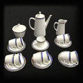 Set parcial del Juego de Café Epiag de Porcelana Fina con tazas, platos y cafetera, diseño elegante en azul, dorado y blanco para decoración.