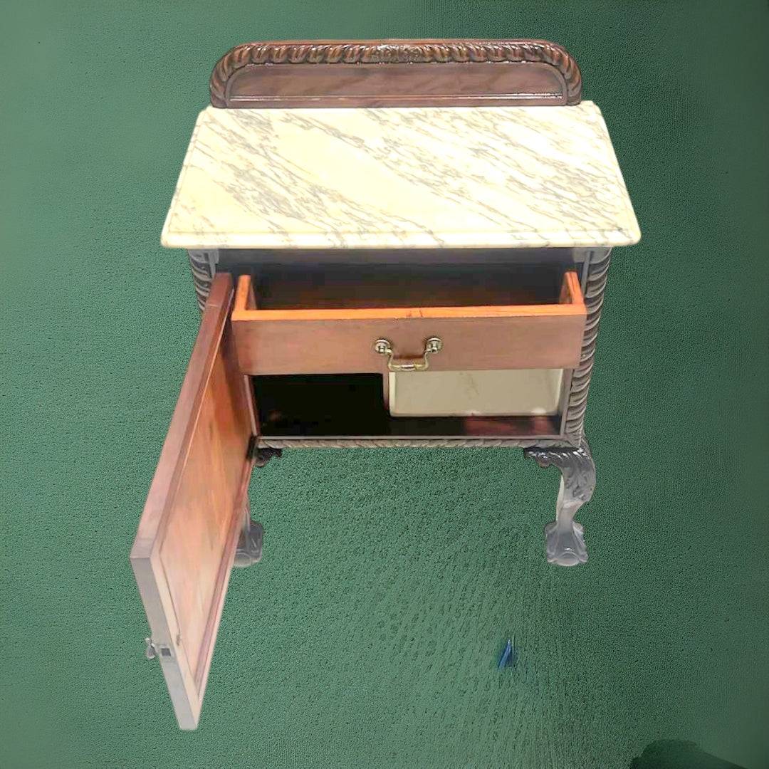 Mesita de noche antigua con tapa de mármol abierta, mostrando cajón superior y compartimento inferior. Perfecta para decoración clásica y funcionalidad.