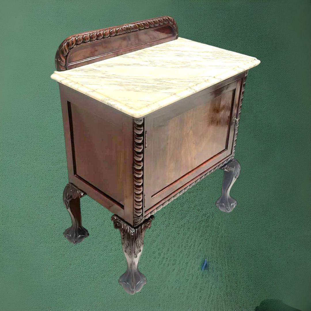 Vista trasera de mesita de noche antigua con tapa de mármol y detalles tallados. Mueble decorativo ideal para dormitorios con estilo clásico.