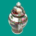 Tibor de cerámica china antigua con tapa, diseño pintado a mano de flores y escenas tradicionales. Perfecto para decoración clásica o coleccionistas.