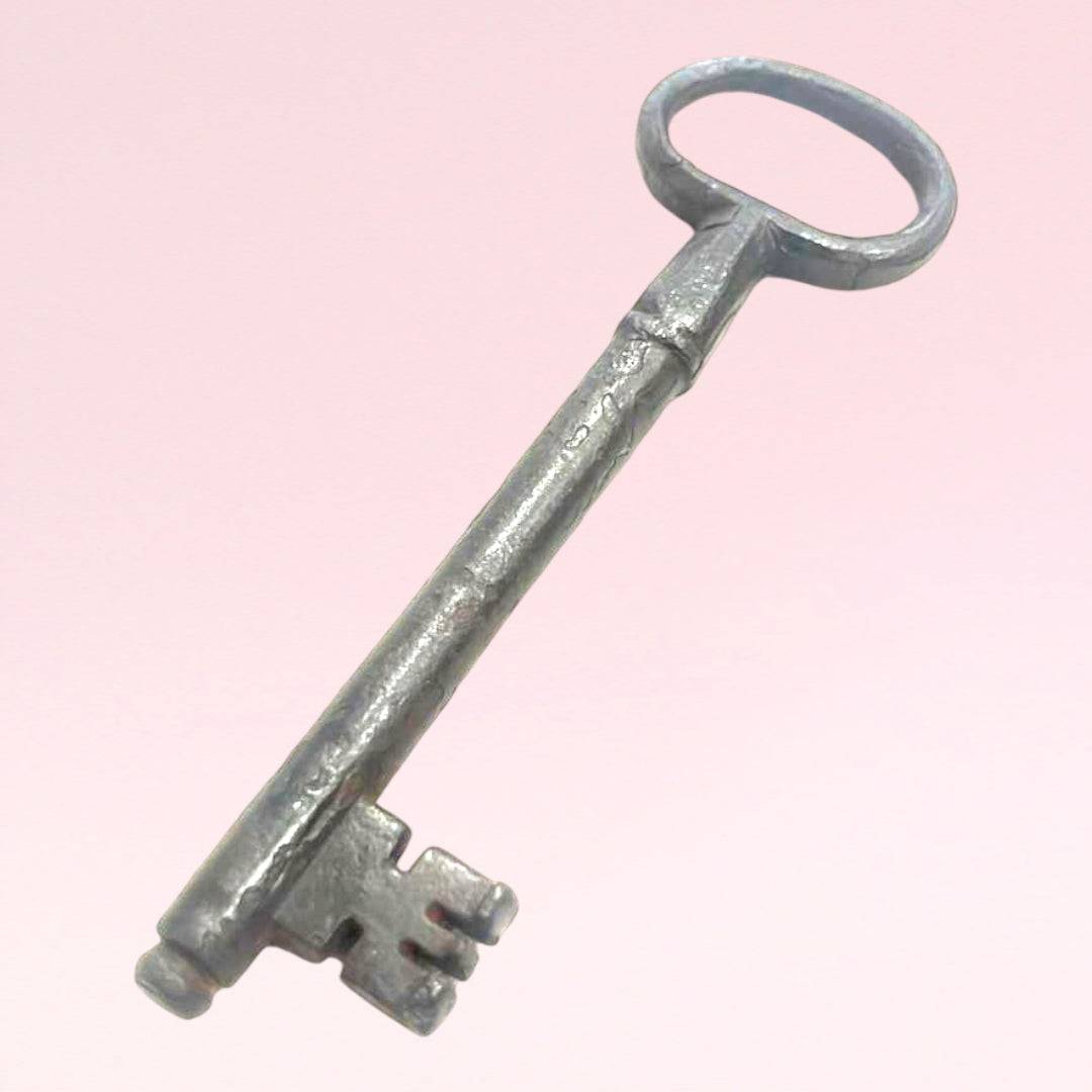 Rara llave antigua de forja en metal envejecido, perfecta para decoración de interiores o coleccionistas de objetos históricos únicos.