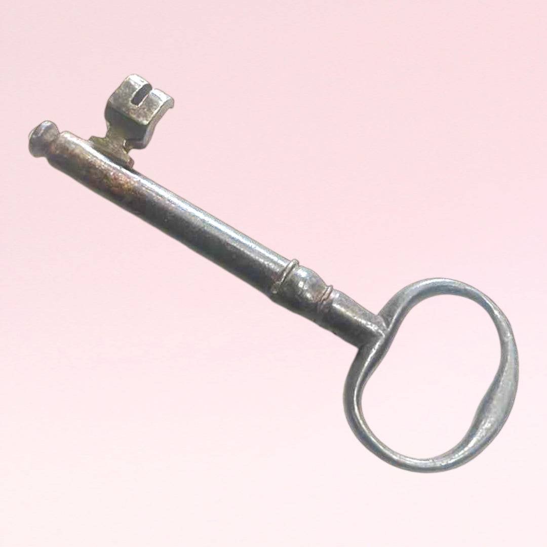 Llave de forja antigua con acabado metálico envejecido, perfecta para decoración vintage en espacios interiores o entradas.