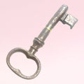 Llave antigua de forja metálica con acabado envejecido, usada como adorno decorativo en interiores de estilo clásico o retro para el hogar.
