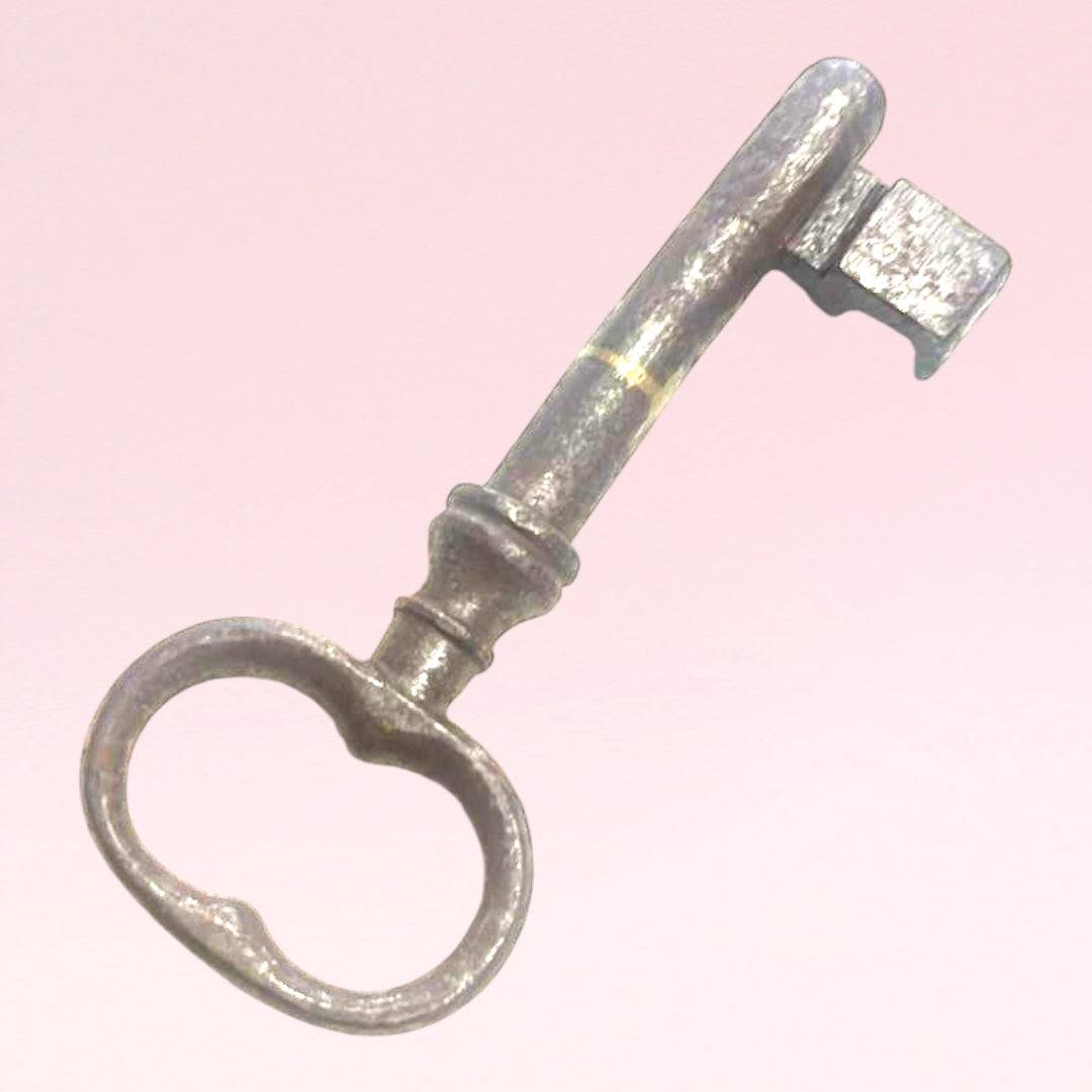 Llave antigua de forja metálica con acabado envejecido, usada como adorno decorativo en interiores de estilo clásico o retro para el hogar.