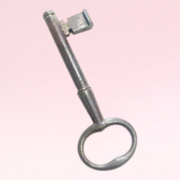 Llave antigua de forja en hierro con diseño clásico, ideal como pieza histórica decorativa para el hogar en estilo vintage.
