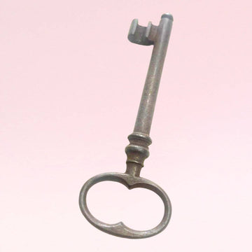 Llave antigua de forja con diseño clásico y acabado envejecido, ideal para decoración vintage en el hogar o jardín.