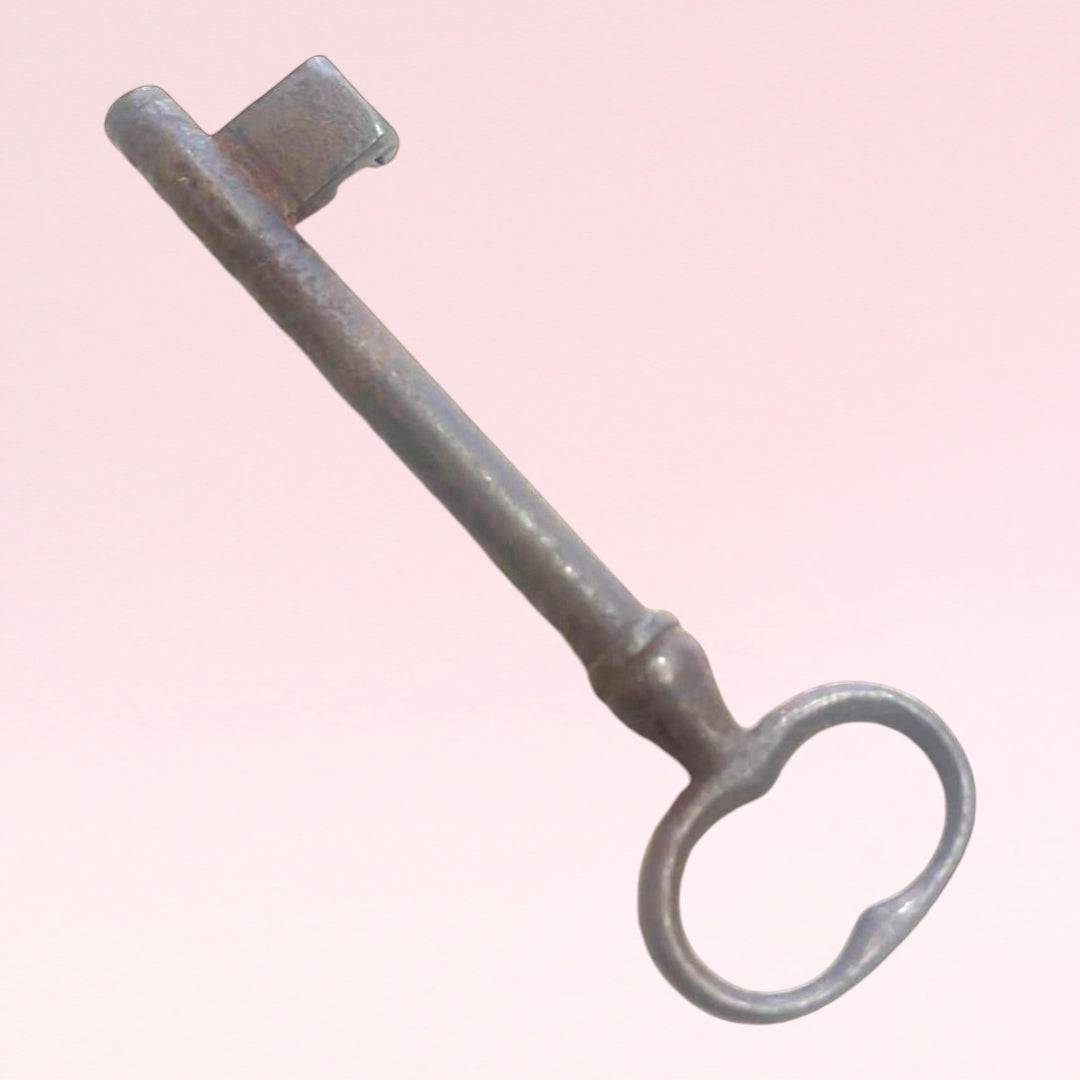 Llave antigua de hierro forjado con acabado envejecido, perfecta para decorar espacios del hogar o jardín con un toque clásico.
