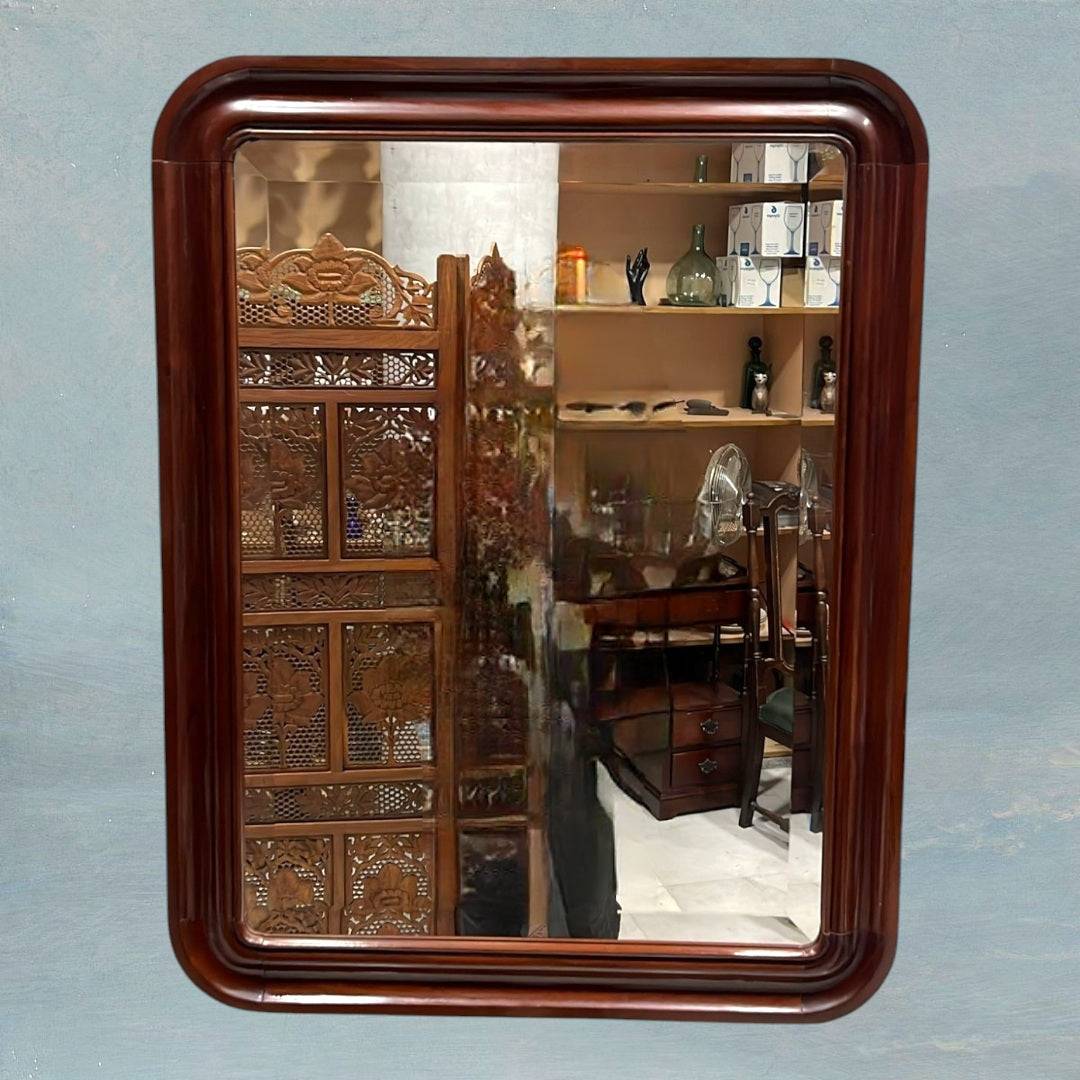 Espejo vintage con marco de caoba, estilo y elegancia atemporal, colgado en pared azul con reflejo de oficina clásica. Ideal para decoración de interiores.
