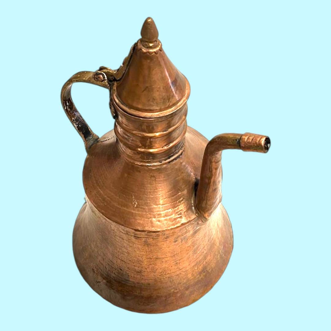 Cafetera/tetera turca de cobre con tapa puntiaguda y caño de cisne, estilo tradicional ideal para decoración de interiores con toques árabes.