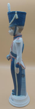 Vista lateral izquierda de la figura de porcelana Lladró Soldado Cadete con Espada, años 80, mostrando detalles del uniforme y espada.