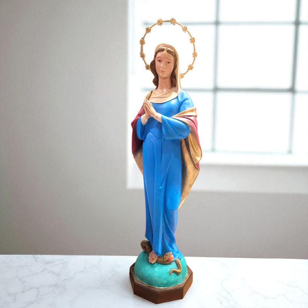 Imagen completa de la Inmaculada Concepción de Olot con aureola dorada y túnica azul sobre pedestal decorativo.