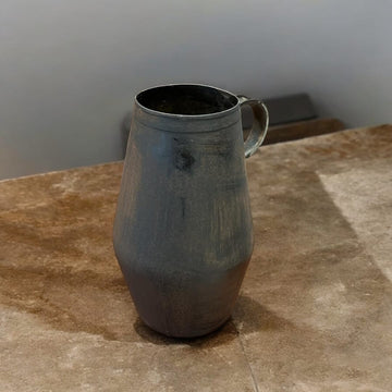 Jarra arrumbador de hierro con diseño rústico y acabado envejecido, ideal para decoración de interiores en estilo vintage.