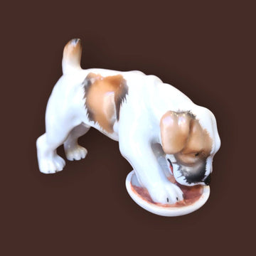 Figura de porcelana alemana de un cachorro beagle comiendo, diseño realista de Limbach años 50, ideal para colección de decoración vintage.