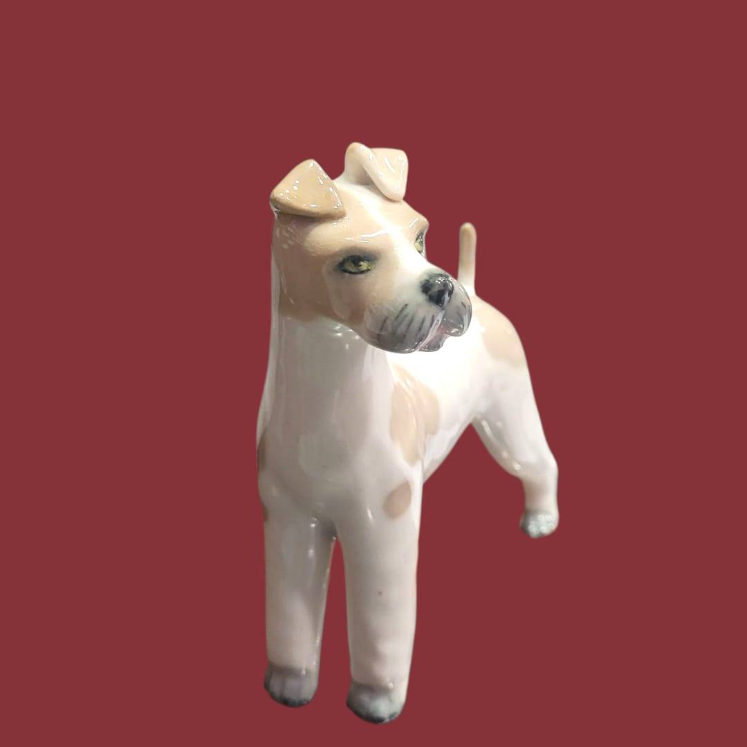 Perro de porcelana Lladró, figura decorativa única con manchas beige y expresión realista, ideal para decoración de interiores.