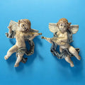 Ángeles músicos de porcelana para pared en fondo azul, con detalles elegantes y armoniosos. Decoración ideal para el hogar.