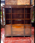 Librería-aparador de caoba maciza con puertas de vidrio abiertas, mostrando amplios estantes. Diseño sofisticado para almacenamiento y exhibición.