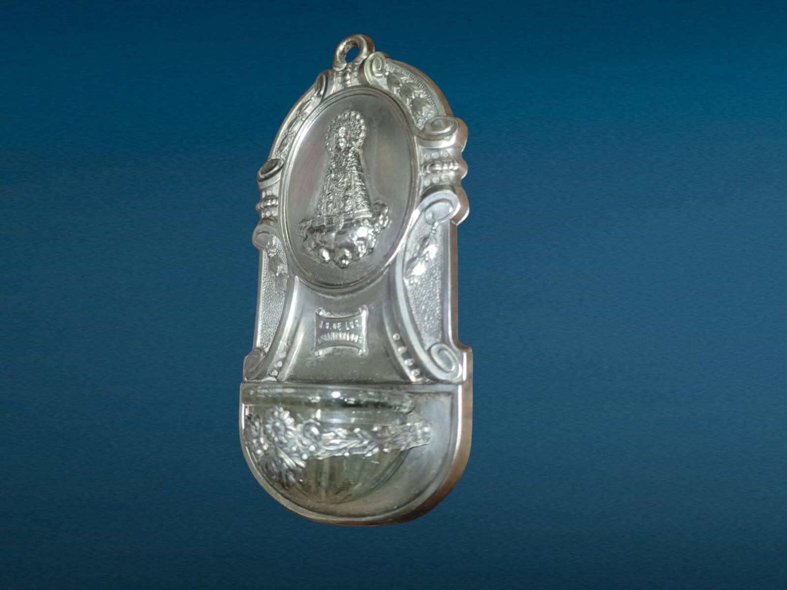 Decoración devocional de pared, benditera antigua de metal plateado con imagen de la Virgen de los Desamparados y recipiente para agua bendita.