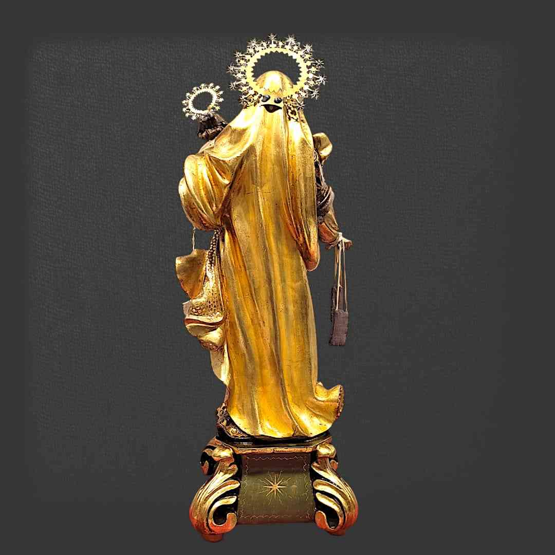 Figura de la Virgen del Carmen de Olot con Niño Jesús, elaborada en pasta de madera, con acabados dorados y base decorativa artesanal.