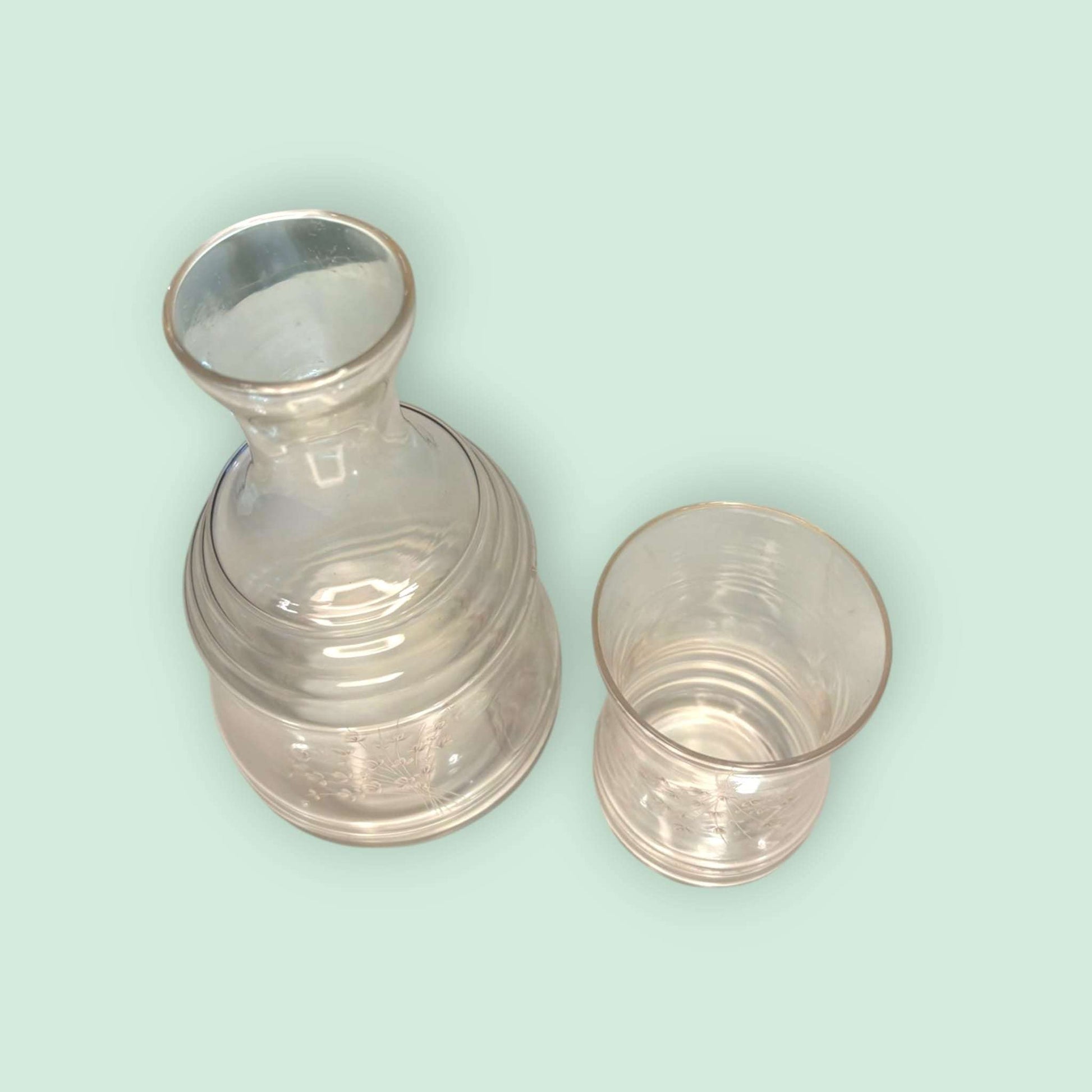 Botella con vaso de cristal antigua para agua grabada, conjunto decorativo de vidrio transparente con detalles florales. Ideal para decoración vintage.