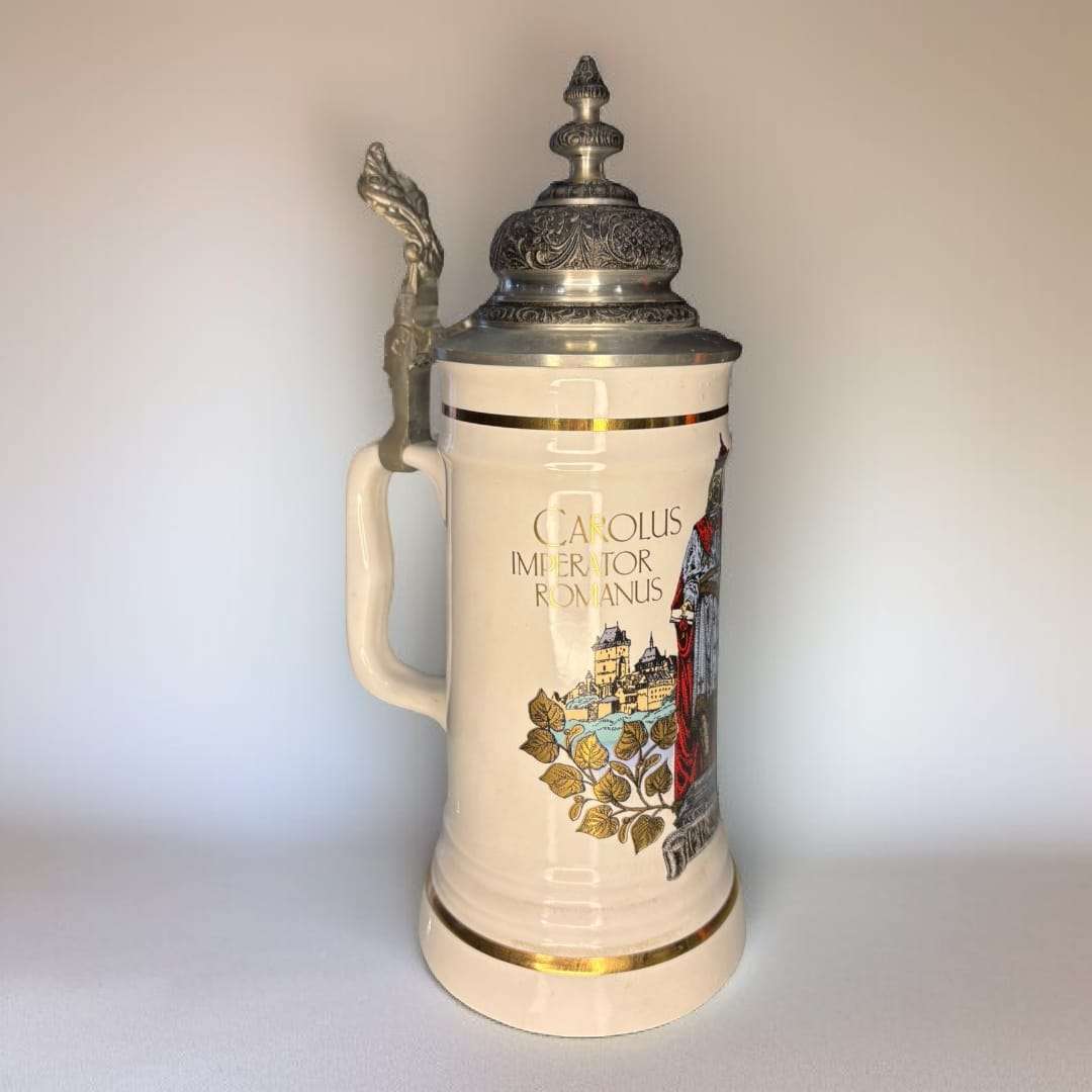 Jarra de cerveza alemana de porcelana con tapa metal grabada, diseño clásico con escudo y texto en latín. Decoración vintage para hogar o bar.