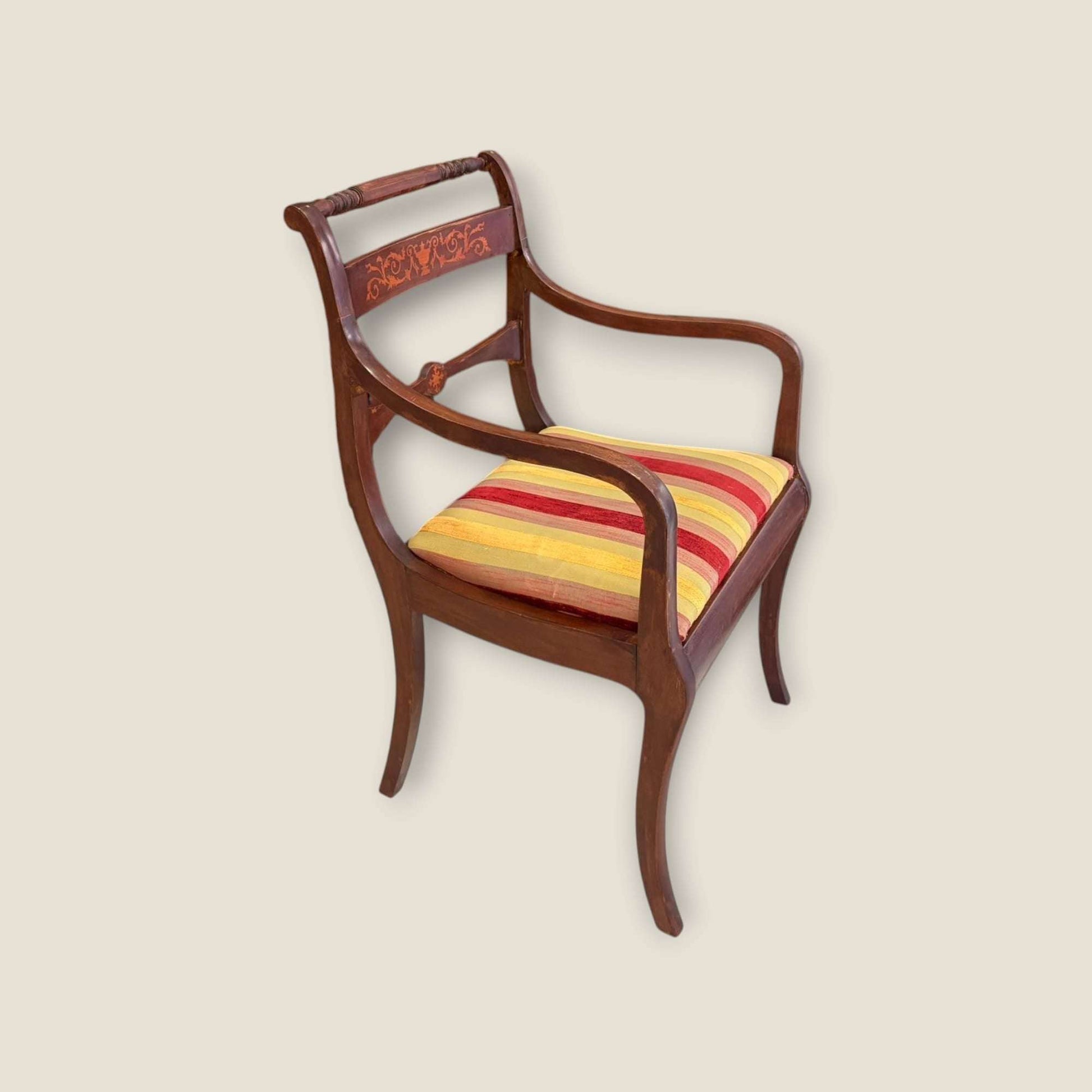 Sillón de caoba con diseño clásico y taracea, brazos estilizados y tapizado a rayas cálidas. Ideal para decoración de hogar con estilo antiguo.