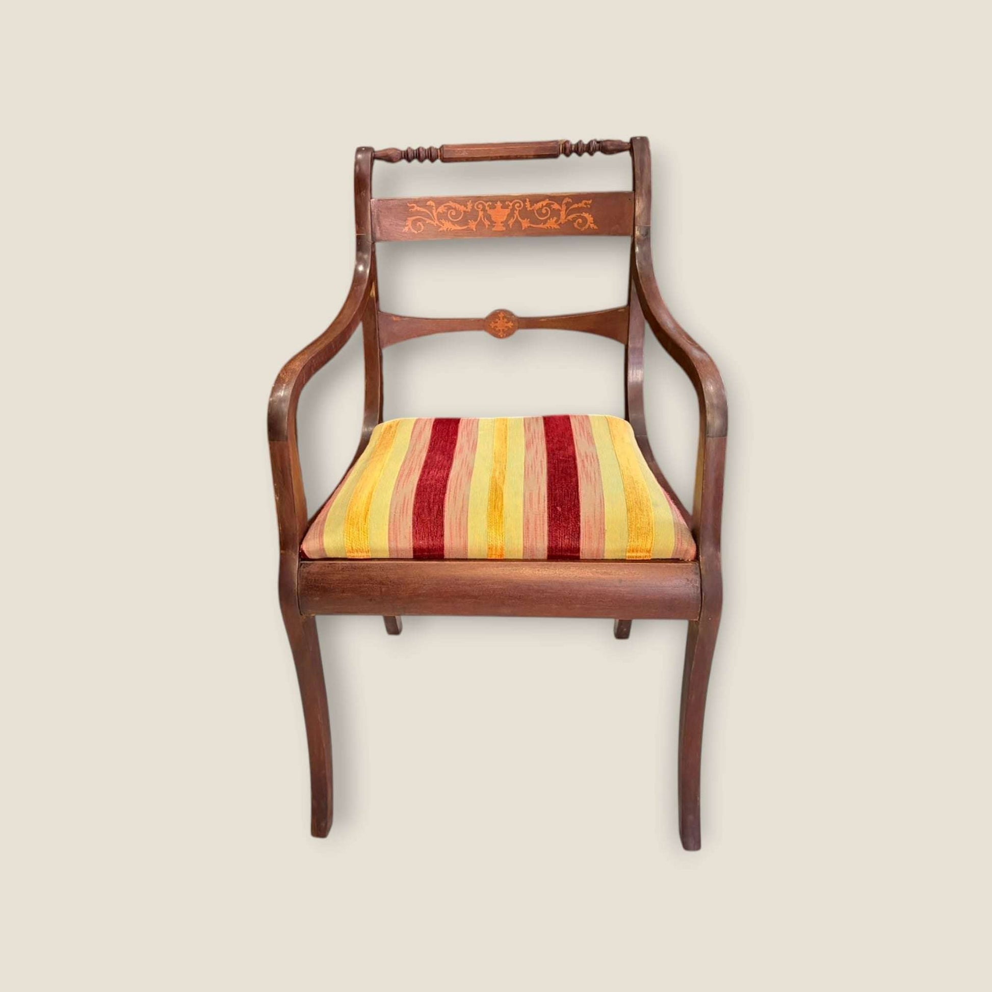 Sillón individual de caoba con taracea y brazos curvos, asiento tapizado a rayas cálidas. Perfecto para despacho o rincón decorativo clásico.