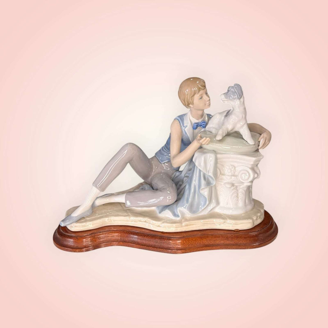 Figura de Niño con perro Nao Lladró en porcelana original, niño recostado acariciando a su perro sobre base de madera, ideal para decoración del hogar.