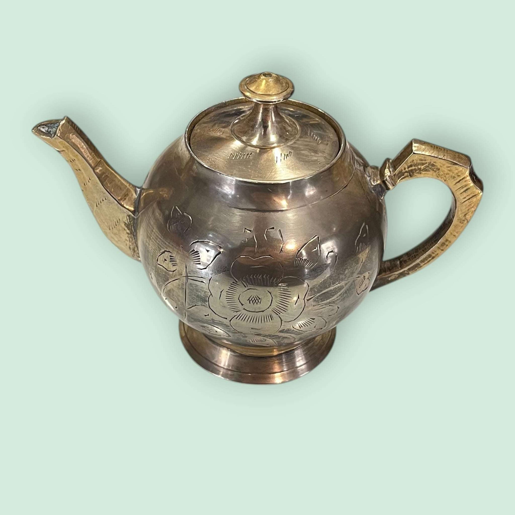 Tetera de metal dorado antigua grabada con tapa, vista en ángulo, excelente para añadir un toque clásico a la decoración del hogar.