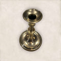 Candelabro de metal dorado con base ancha y forma torneada, ideal para velas decorativas en ambientes clásicos o coleccionismo.