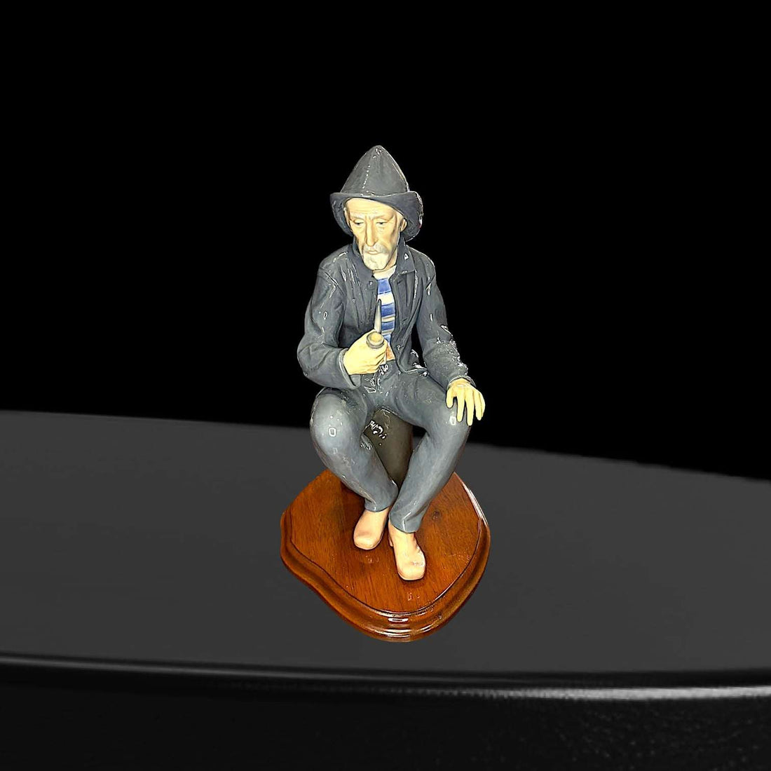 Figura artesanal Lladró de marinero fumando pipa, sentado sobre base de madera. Decoración de porcelana para hogar, pieza de colección única.