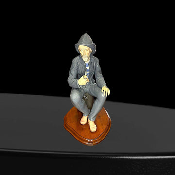 Figura artesanal Lladró de marinero fumando pipa, sentado sobre base de madera. Decoración de porcelana para hogar, pieza de colección única.
