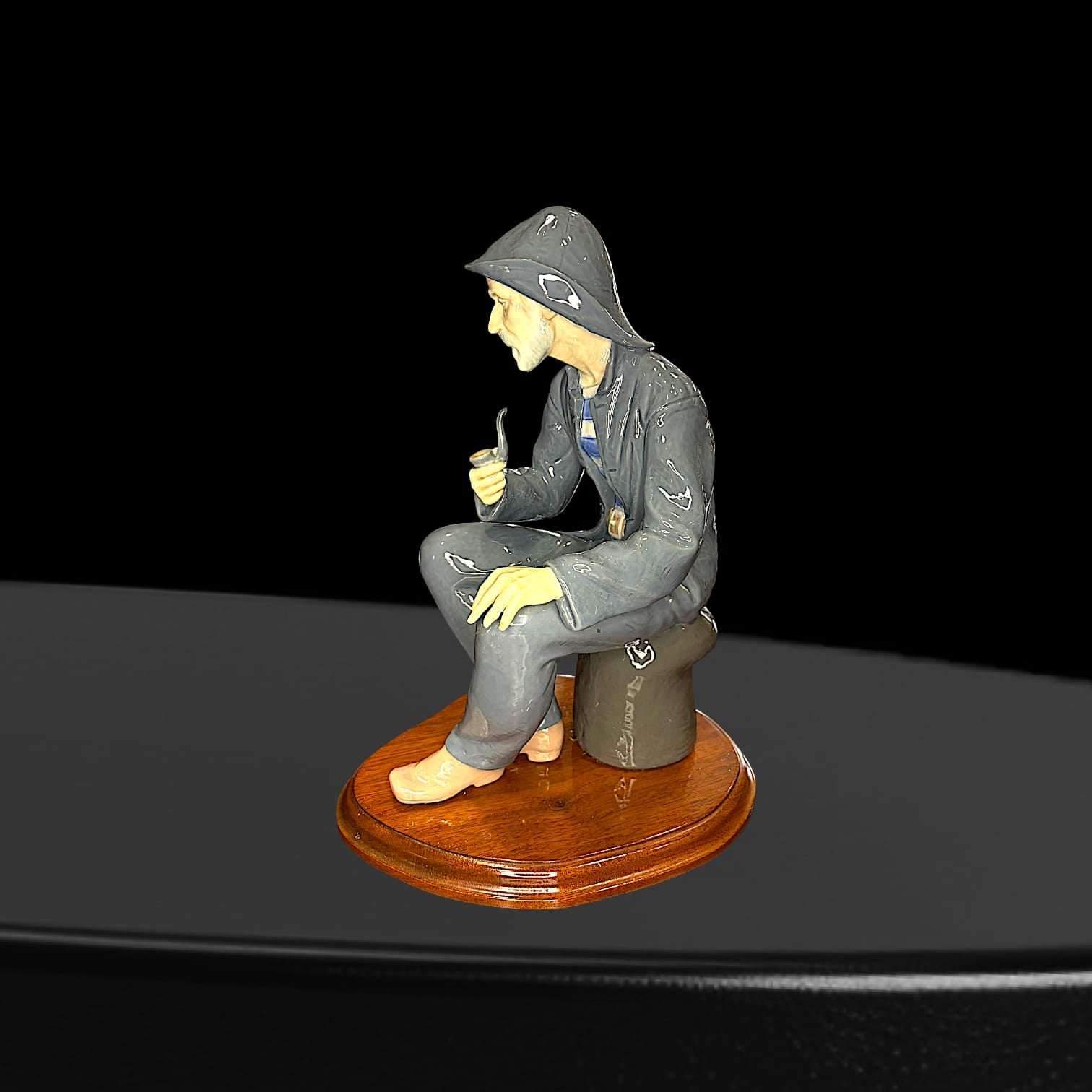 Figura decorativa Lladró de marinero fumando pipa, vista lateral derecha. Porcelana española con acabado artesanal, ideal para coleccionistas.