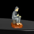 Perfil izquierdo de figura Lladró marinero fumando pipa, sentado con expresión serena. Porcelana artesanal sobre base de madera, decoración artística.