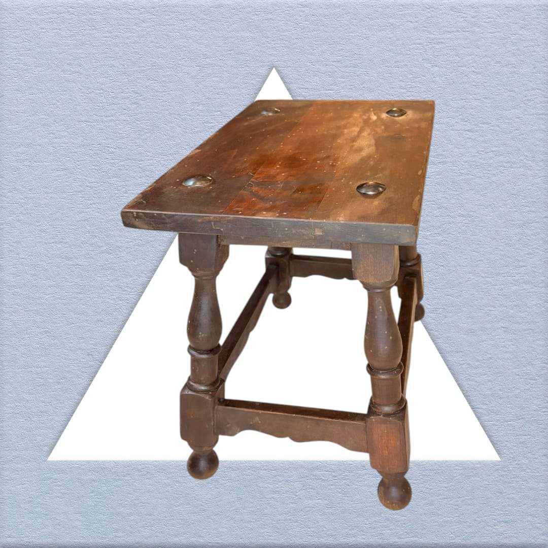 Mesa auxiliar de estilo Castellano con superficie de madera maciza y detalles metálicos. Perfecta para ambientes vintage o tradicionales.
