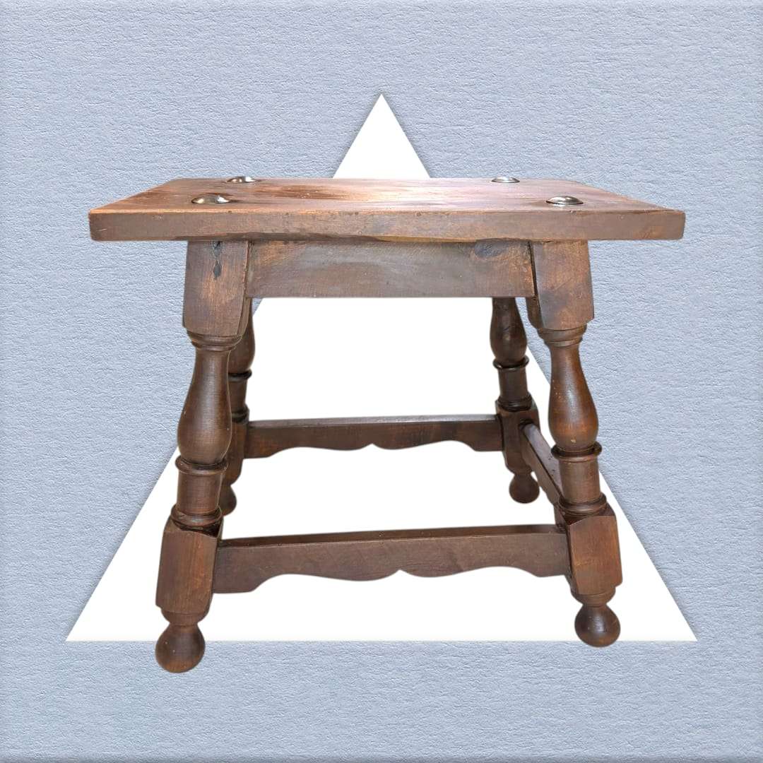 Mesa auxiliar Castellana antigua con estructura robusta y diseño artesanal. Complemento decorativo para espacios de estilo colonial.