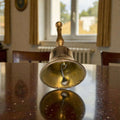 Campana de metal dorado antigua vista desde abajo mostrando el badajo. Ideal como pieza decorativa con historia en vitrinas o salones.