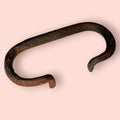 Tirador de hierro antiguo con diseño plegable, parte de una pareja de asas de baúl únicas. Ideal para restauración de muebles vintage.