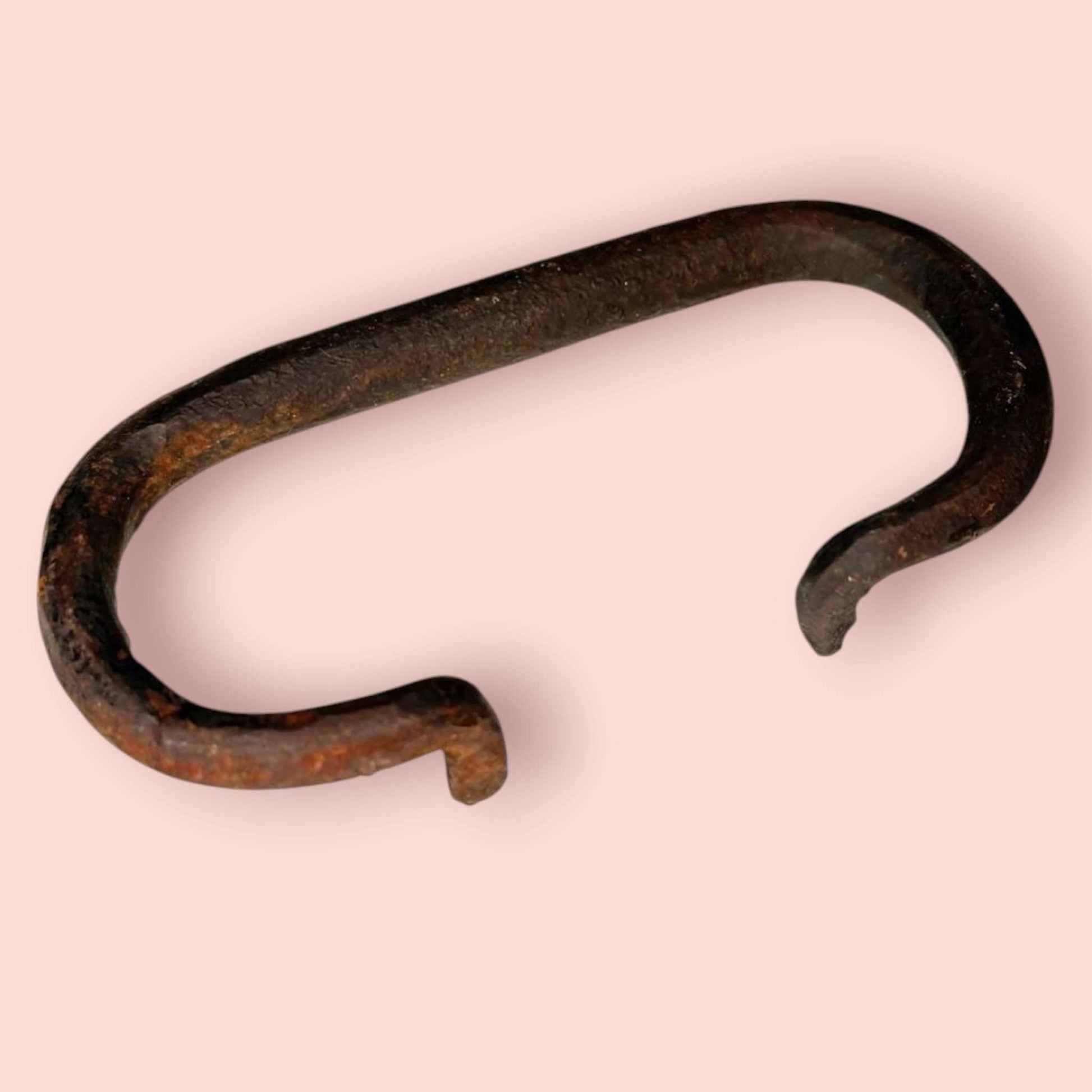 Tirador de hierro antiguo con diseño plegable, parte de una pareja de asas de baúl únicas. Ideal para restauración de muebles vintage.