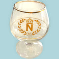 Copa Napoleón de cristal con decoración dorada, emblema imperial y borde dorado. Ideal para decoración elegante o colección vintage.
