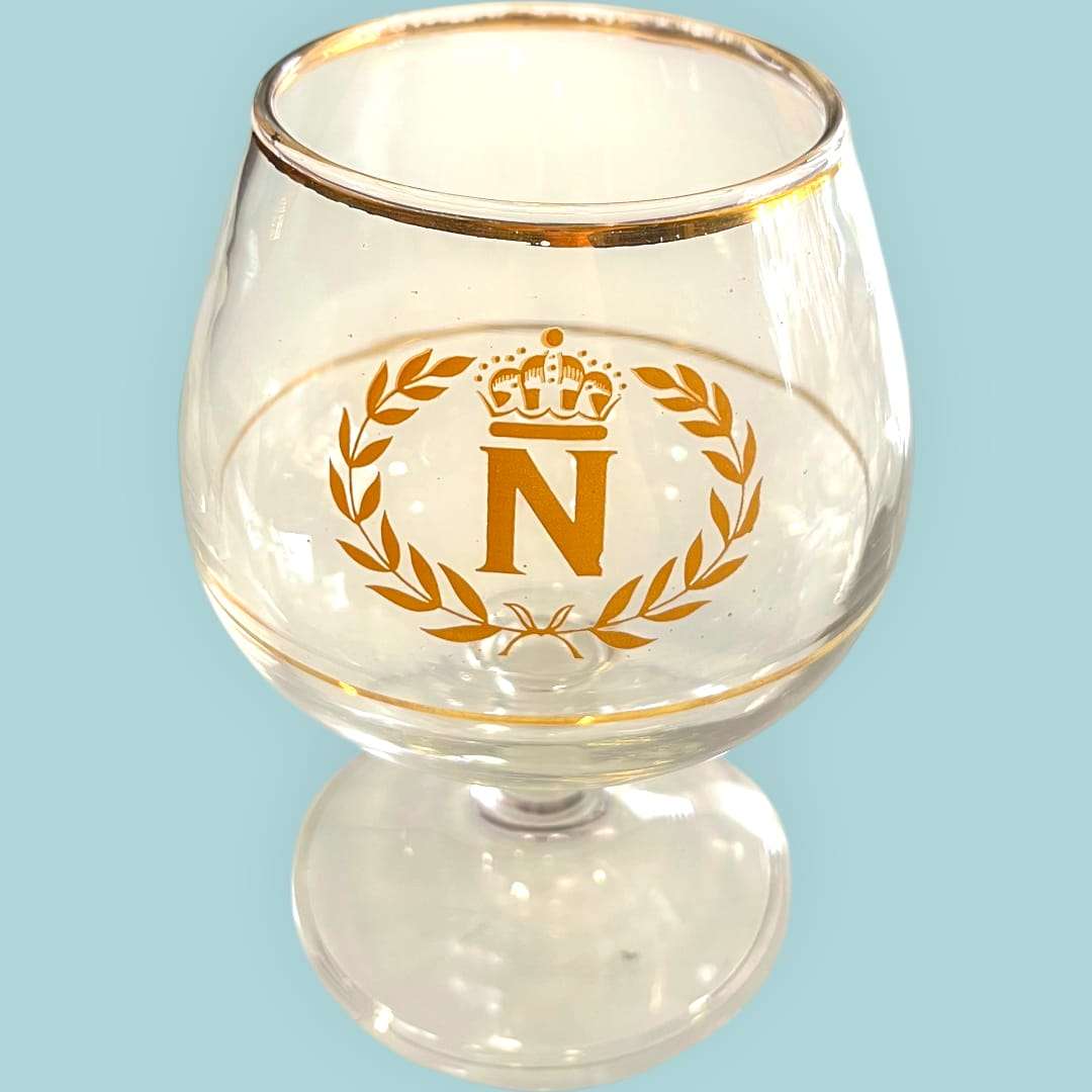 Copa Napoleón de cristal con decoración dorada, emblema imperial y borde dorado. Ideal para decoración elegante o colección vintage.