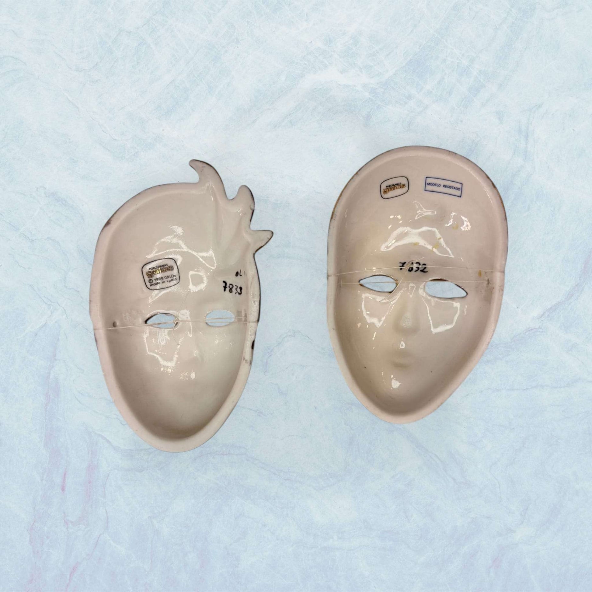 Reverso de máscaras de porcelana venecianas Galos y Ocer únicas mostrando etiquetas de autenticidad, ideales para coleccionistas de decoración.