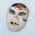 Máscara de porcelana veneciana Galos y Ocer única con flores pintadas a mano y labios dorados, ideal para decoración artística de interiores.