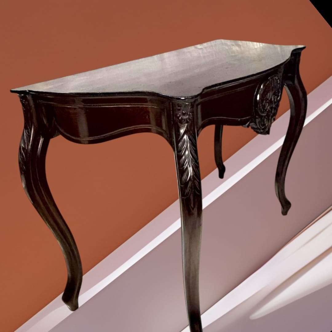 Consola isabelina de caoba con detalles tallados en las patas y estructura ondulada. Pieza decorativa exclusiva para interiores clásicos.