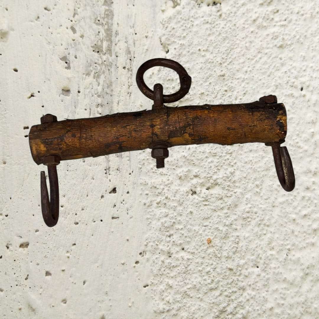 Detalle del balancín de madera con anillos de forja vintage