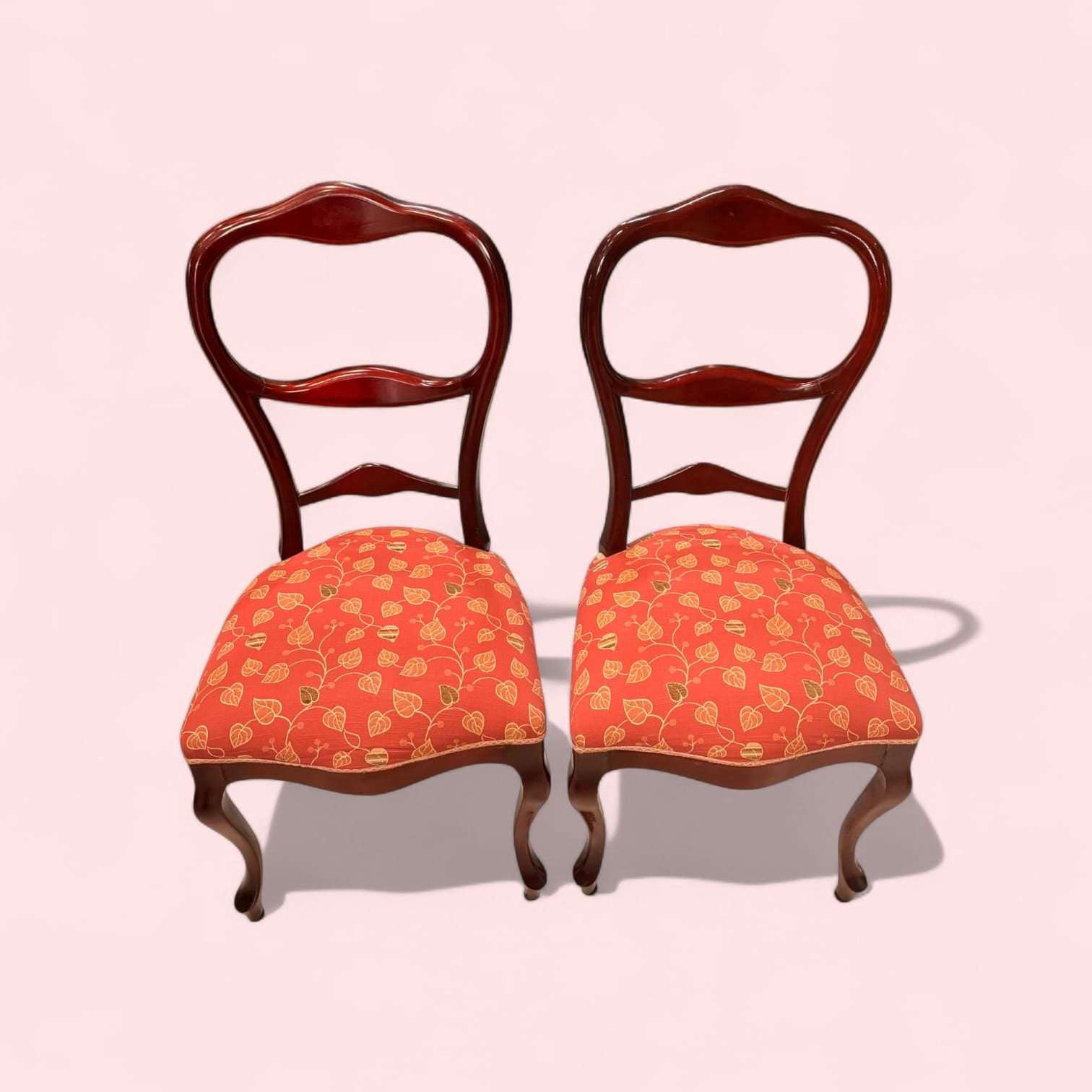 Pareja de sillas clásicas de madera con tapizado floral en tonos rojos y patas cabriolé para decoración de hogar