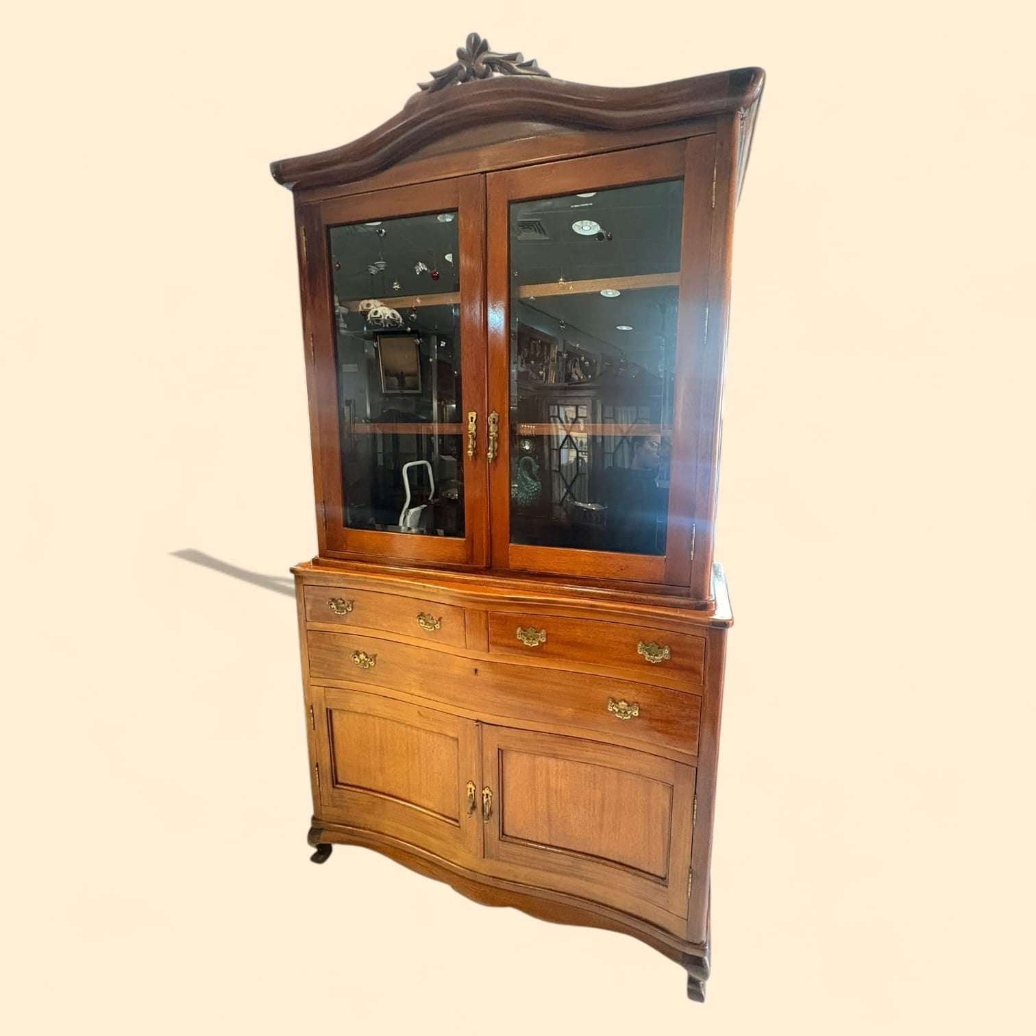 La parte alta dispone de dos puertas acristaladas, con interior amplio y baldas para exposición. En la parte media se ven tres cajones, dos superiores más pequeños y uno central de mayor tamaño, perfectos para organizar cubertería, mantelería, documentos o pequeños accesorios
