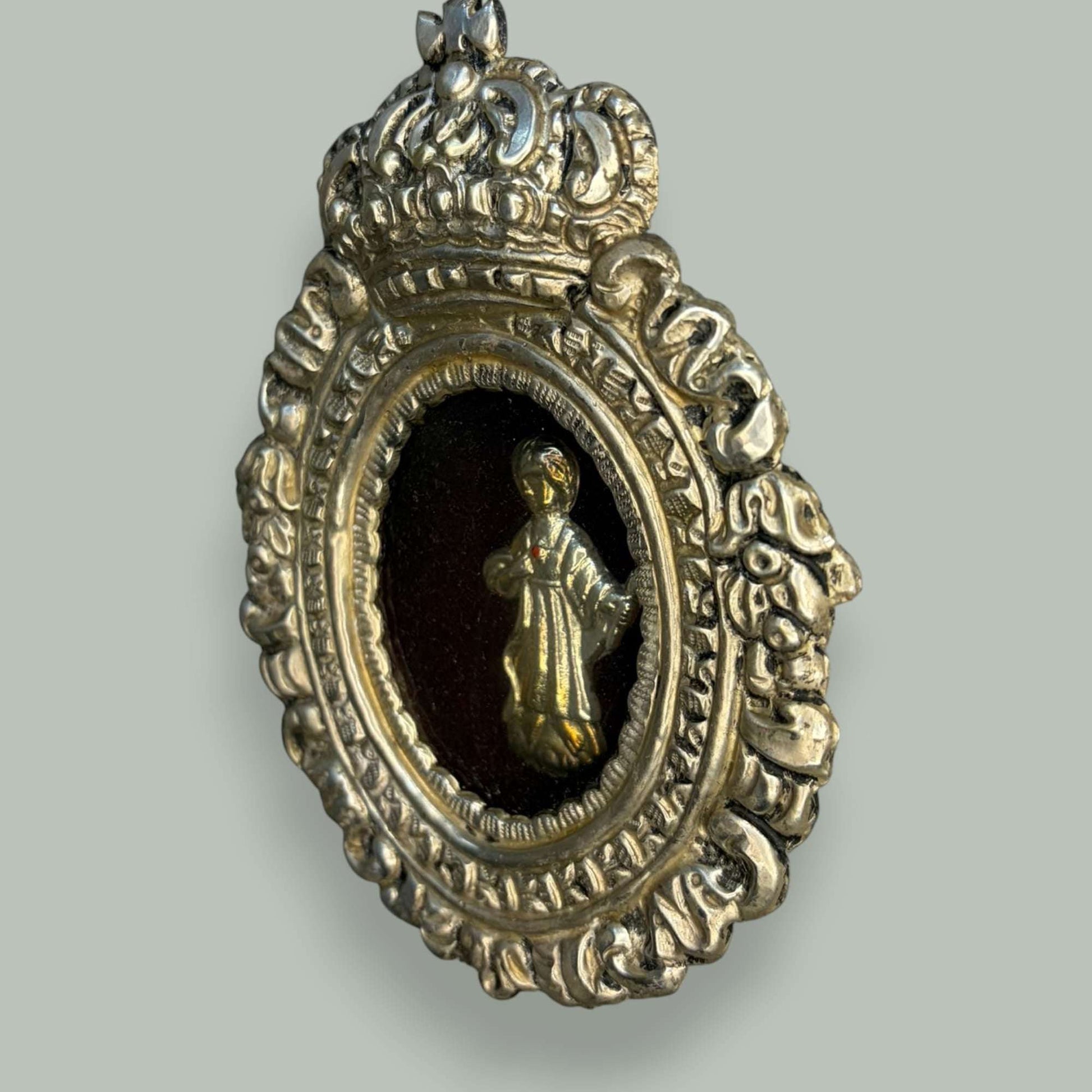 Lo que hace singular a este relicario de metal plateado es la riqueza ornamental que se aprecia con claridad en las fotografías. 