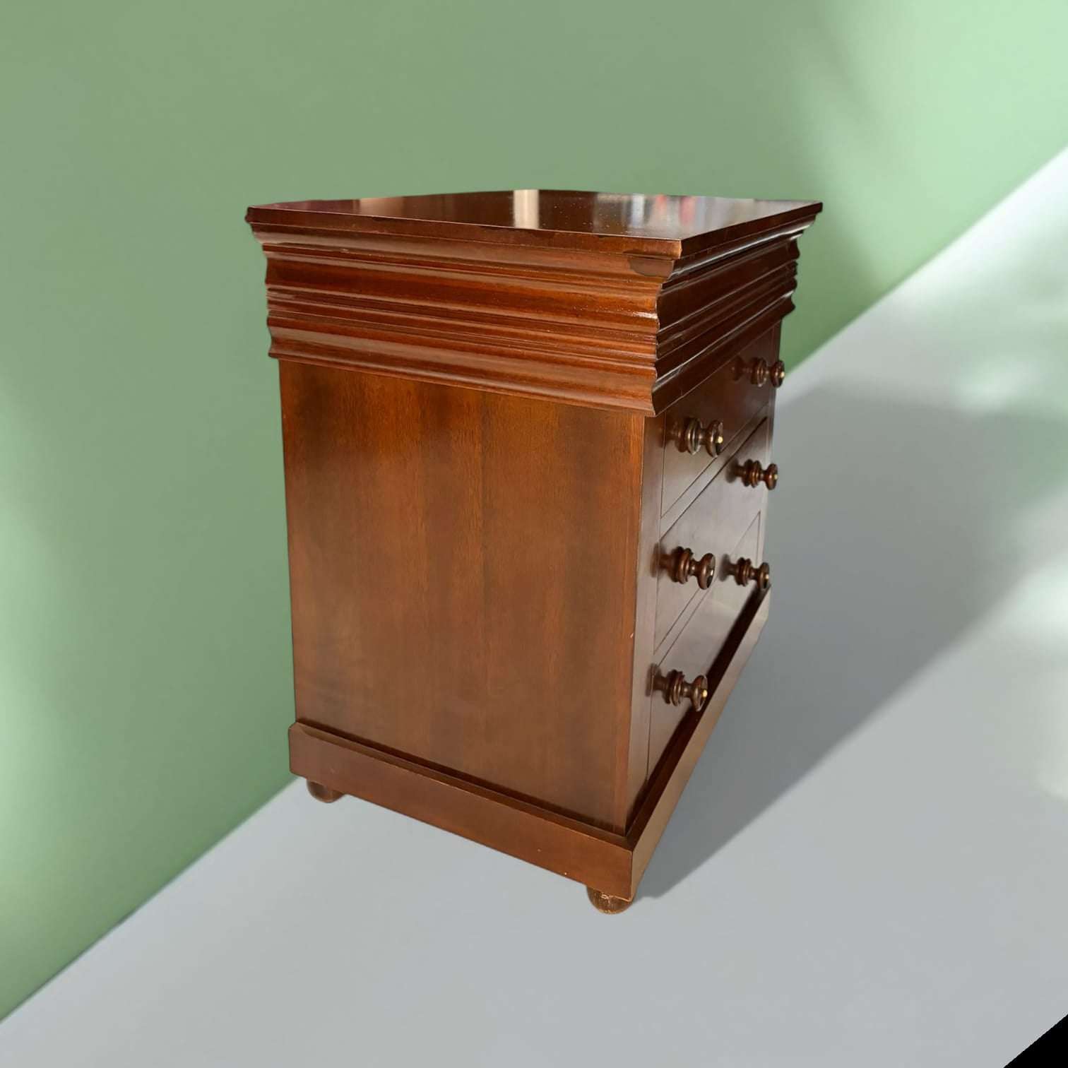 En las imágenes se aprecia una estructura sólida y bien proporcionada, con tapa rectangular, cuerpo recto, molduración superior marcada y tres cajones frontales visibles con pomos torneados oscuros. 
