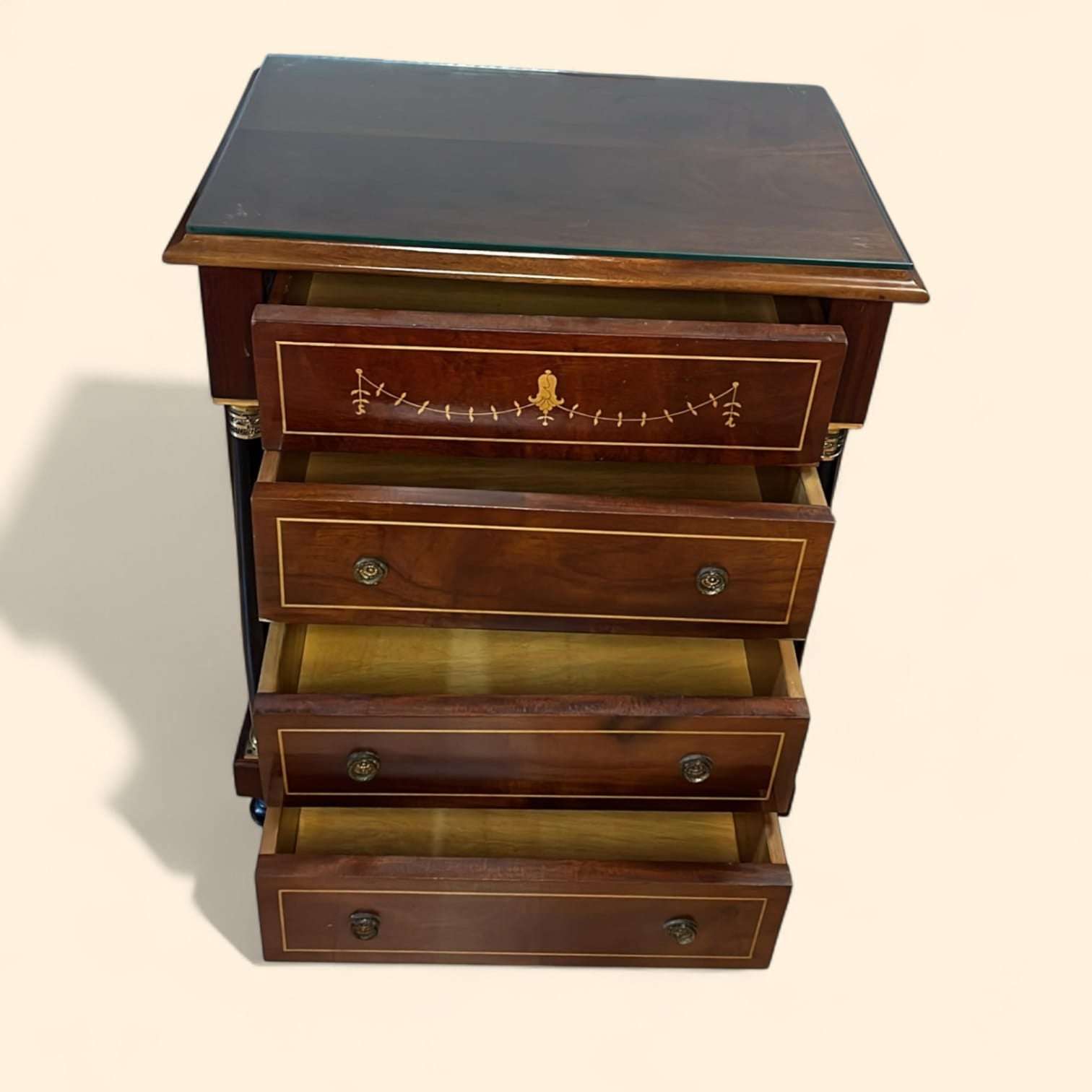 En las imágenes se aprecia un cuerpo de líneas rectas y elegantes, enriquecido por una decoración muy fina de taracea lineal en los frentes y un delicado motivo central en el cajón superior, que realza su carácter decorativo. 