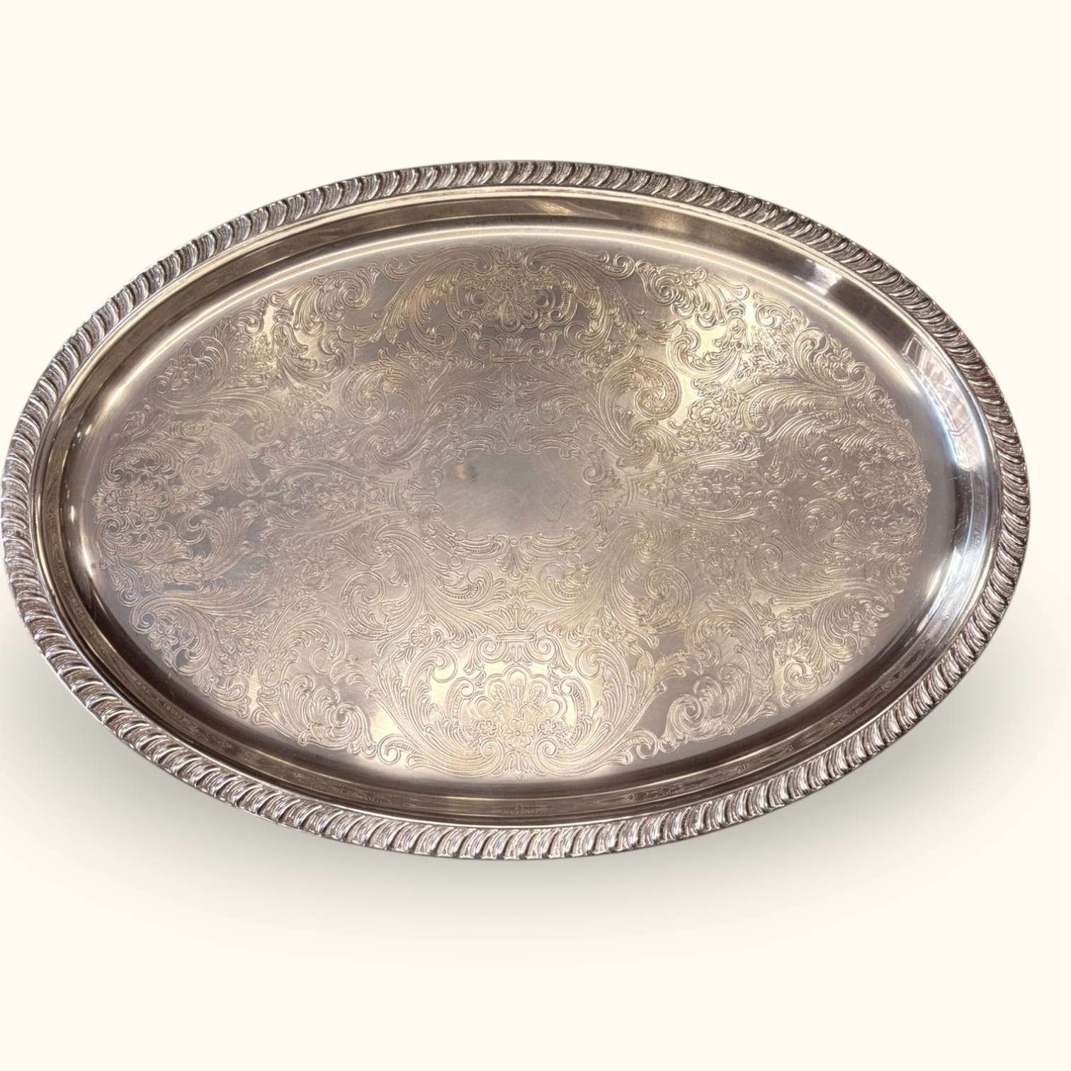Bandeja antigua de metal plateado con relieves decorativos y borde elevado